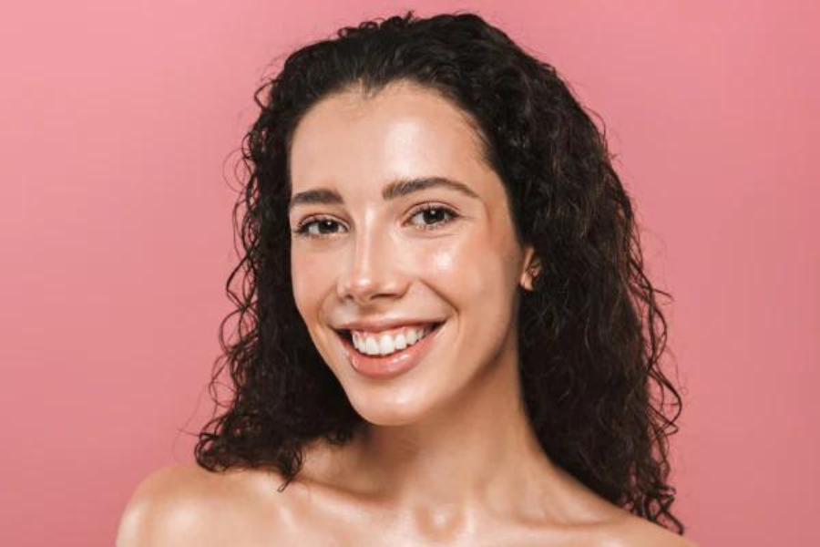 Girl looking at the camera with brunette hair and dewy skin